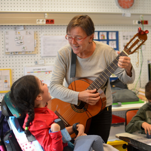 La musicoterapeuta del centre, cantant un garrotin a una alumna